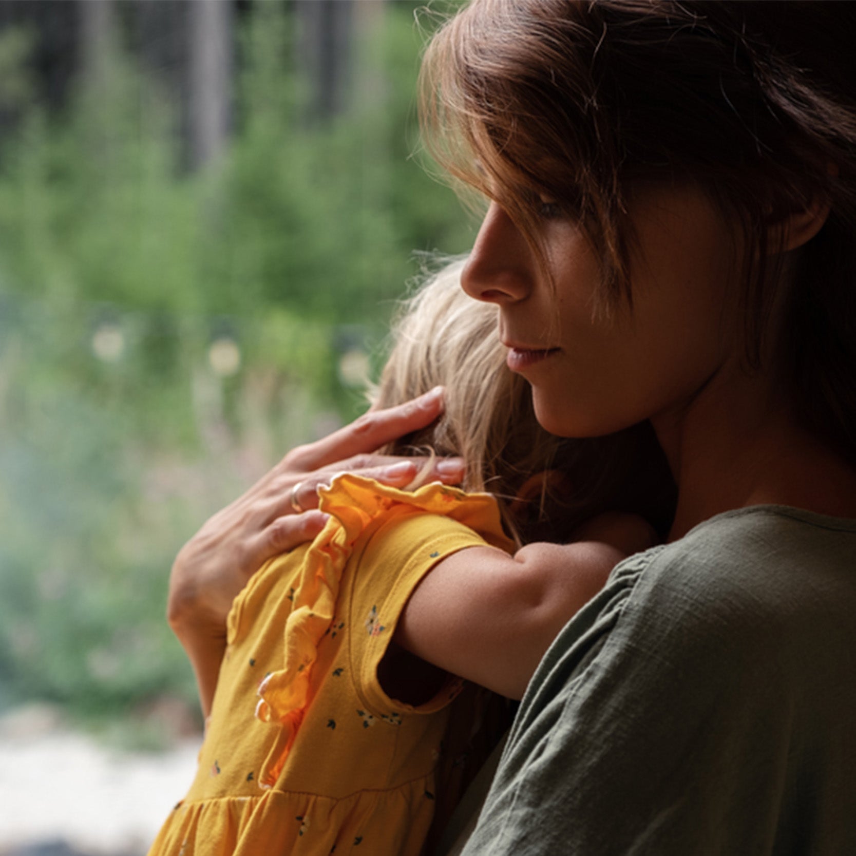 blonde toddler carried by mother