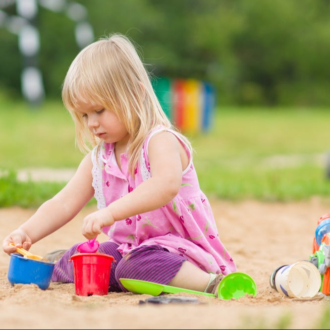 Young girl playing in a sandbox