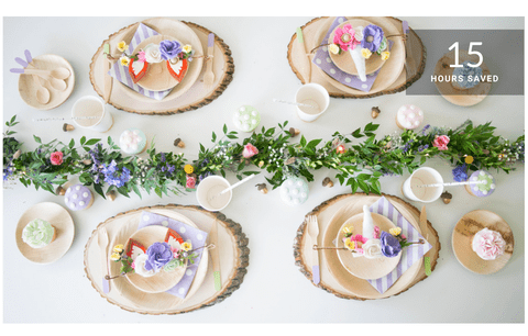 Overhead view of a unicorn-themed children’s party table with wood-slice chargers, pastel plates, floral garland and overlay text ‘15 hours saved’