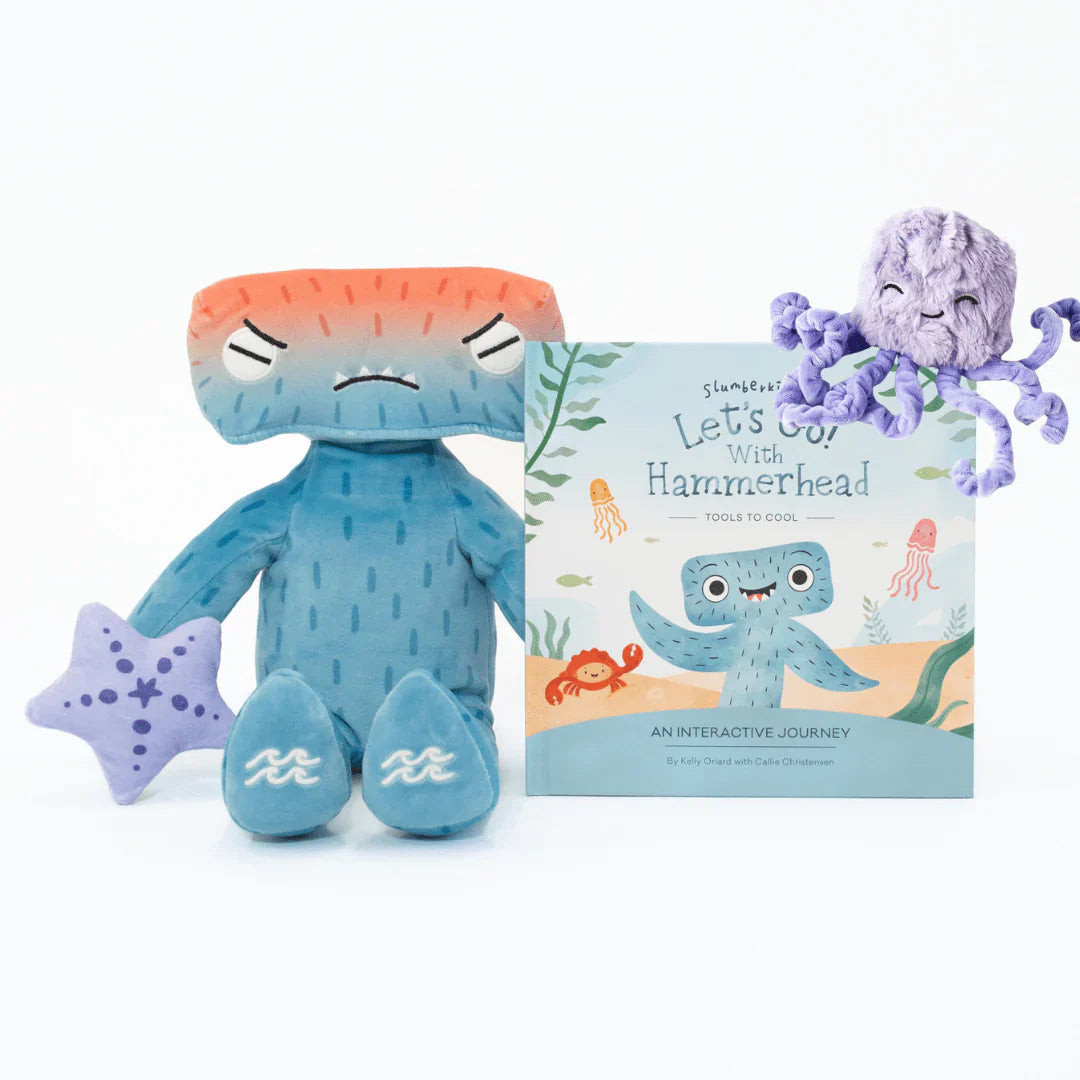 Front view of Hammerhead plush with angry face, paired with the activity book Let’s Go With Hammerhead and a purple octopus on white background
