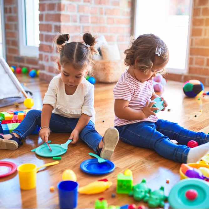 Two young children learning teamwork while playing