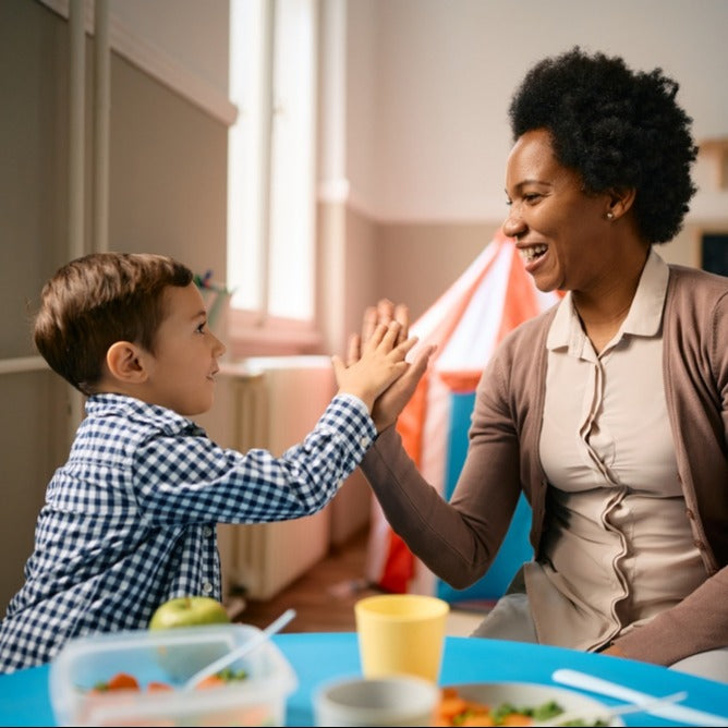 Teacher and young child high fiving